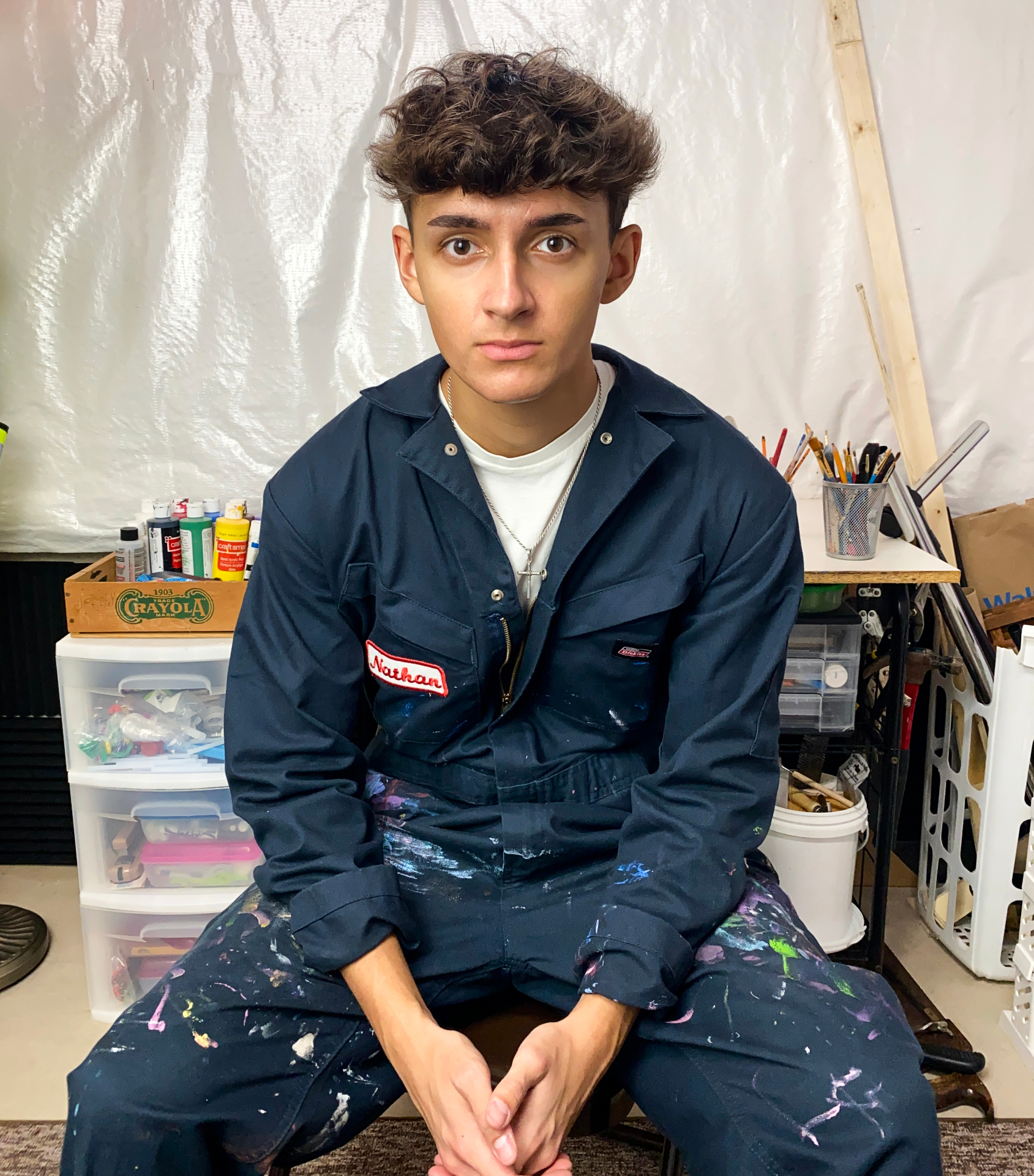 Nathan in his studio wearing paint-splattered coveralls